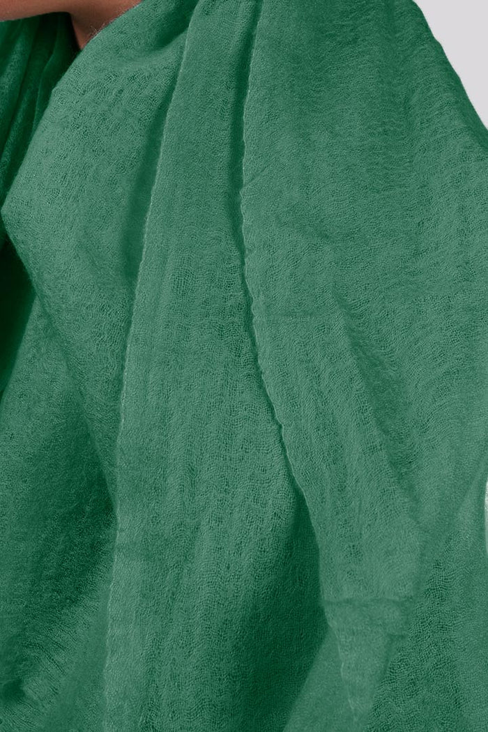 Close-up view of the forest green cashmere scarf shows the intricacies of the weave.