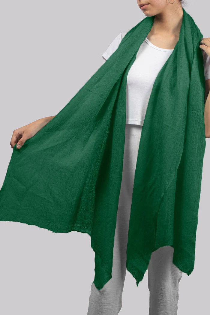 A female model displaying the wrap size of our forest green cashmere scarf.